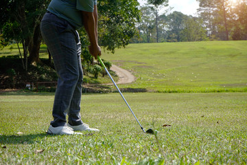 Blurred golfer playing golf in the evening golf course, on sun set evening time.