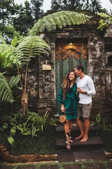 Foto op Plexiglas Happy couple in love smiling and kissing on background of traditional balinese architecture. Welcome to travel in Bali concept, vacations honeymoon in Asia. © Oleg Breslavtsev