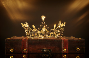 low key image of beautiful queen/king crown over wooden table. vintage filtered. fantasy medieval...
