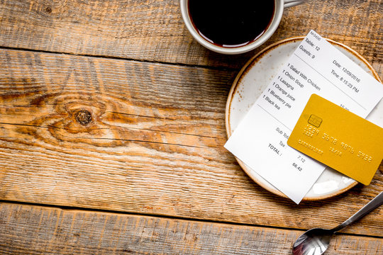 coffee and receipt bill for payment by credit card on wooden table background top view mockup