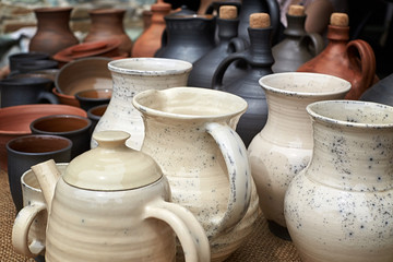 Fototapeta na wymiar Many clay jugs with locks and vessels