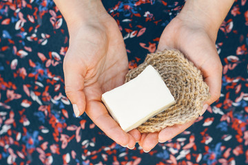 Eco-friendly cleaning kit. Organic soap and jute washcloth in the woman's hand. Zero waste concept, plastic-free, eco-friendly shopping, vegan