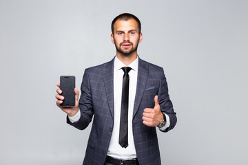 Business, people and technology concept. happy smiling businessman in suit showing smartphone black blank screen