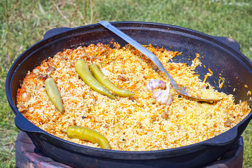 Traditional delicious pilaf with vegetables in a cauldron