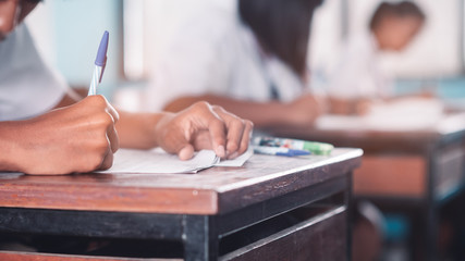 Student doing test or exam  in classroom of school with stress
