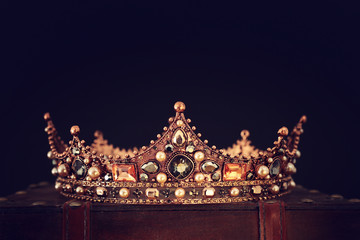 low key image of beautiful queen/king crown over wooden table. vintage filtered. fantasy medieval...