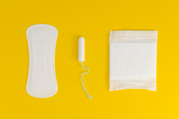 Flat lay sanitary napkins, pads and tampon on a yellow background. Menstrual cycle and ovulation idea