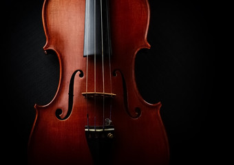 The wooden violin put on black canvas background,show front side of string instrument,vintage and art tone,blurry light around