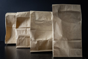 Paper craft gift bags in a row on a black background