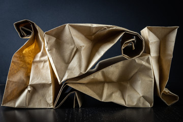 Naklejka premium 4 paper craft gift bags on a black background neatly and symmetrically folded