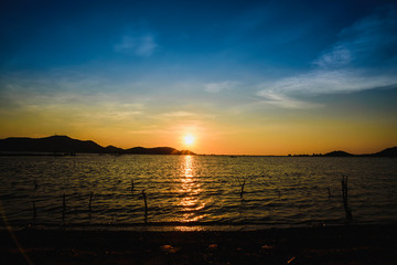 Reservoir with surrounding mountains and beautiful skies in Thailand.