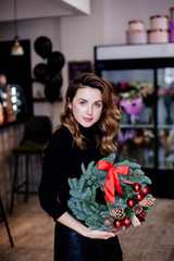 Woman holds christmas wreath. Florist.