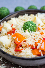 Colorful long basmati rice with vegetables in bowl with spinach green ball. Vegan or vegetarian healthy food.