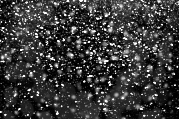 Texture of white snow blurry bokeh isolated black background. falling snow overlay. star sky. Black spots on white background, white drops and spots