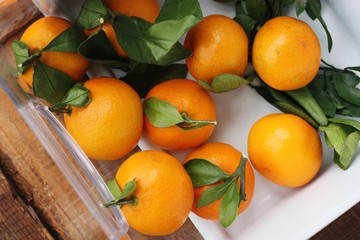 Juicy fresh tangerines with leaves on the table 