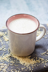 Plant milk. Plant based non-diary milk healthy vegan drink with sesame seeds in cup or mug. No milk diary