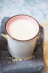 Plant milk. Plant based non-diary milk healthy vegan drink with sesame seeds in cup or mug. No milk diary