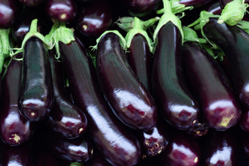 Pile of ripe fresh eggplants, close up. - obrazy, fototapety, plakaty