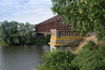 Old Train Steel Bridge over river at sunset