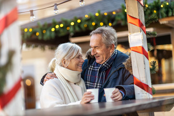 Happy senior couple having fun on the Christmas Market