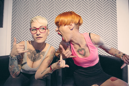Ragazze tatuate scherzano davanti alla macchina fotografica