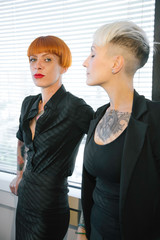 Giovani ragazze tatuate discutono in ufficio