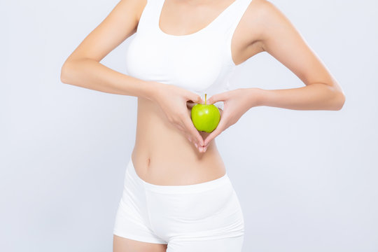 Closeup asian woman holding green apple fruit shape heart and beautiful body diet with fit isolated on white background, girl weight slim with cellulite or calories, health and wellness concept.