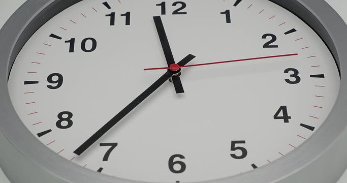 Truck shot of time-lapse gray clock with black arrows shows motion the time speed up from 11.00 p.m. and slow down to 12.00 p.m., How time flies concept.