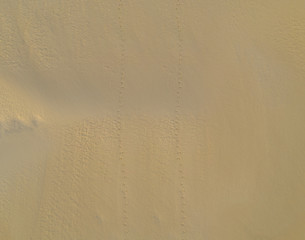 Two sets of footprints in the sand aerial