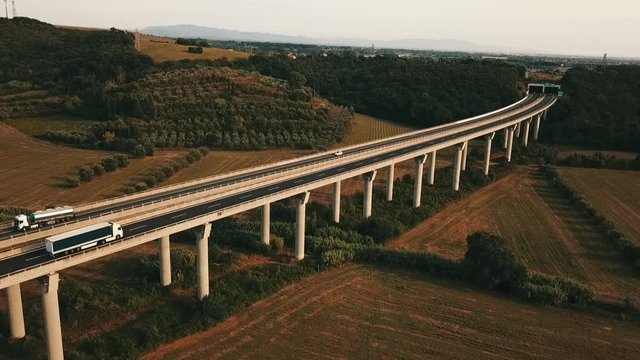 Aerial: Bridge with cars and trucks passing in a beautiful countryside with pastures and meadows in south Germany
