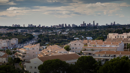 Fototapeta na wymiar Editorial ALTEA, SPAIN - NOVEMBER 23, 2019: A view over the rooftops from Altea and the skyline buildings of Benidorm on the Costa Blanca, Spain