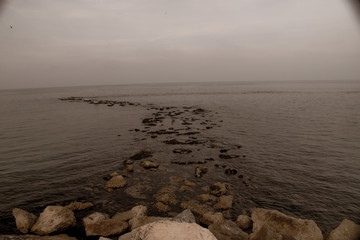 a path of stones in the sea in a cloudy day