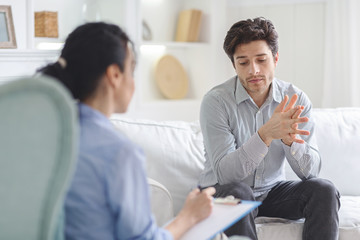 Stressful man emotionally speaking at psychotherapist session