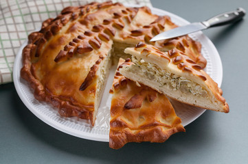 Close-up homemade cabbage pie on a cutting board. Russian and Ukrainian traditional national cuisine. Food Delivery Concept