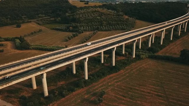 Aerial: Bridge with cars and trucks passing in a beautiful countryside with pastures and meadows in south Germany