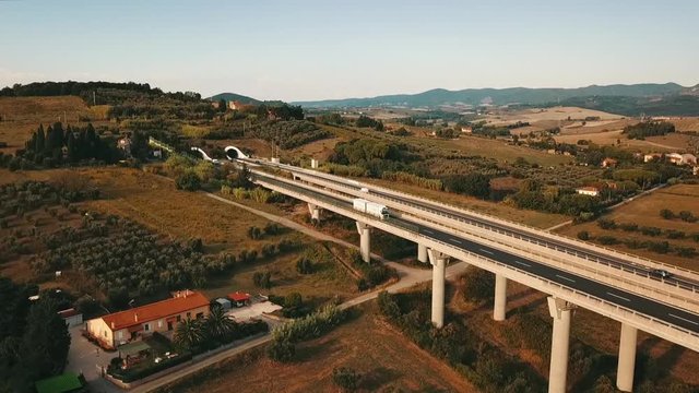 Aerial: Bridge with cars and trucks passing in a beautiful countryside with pastures and meadows in south Germany