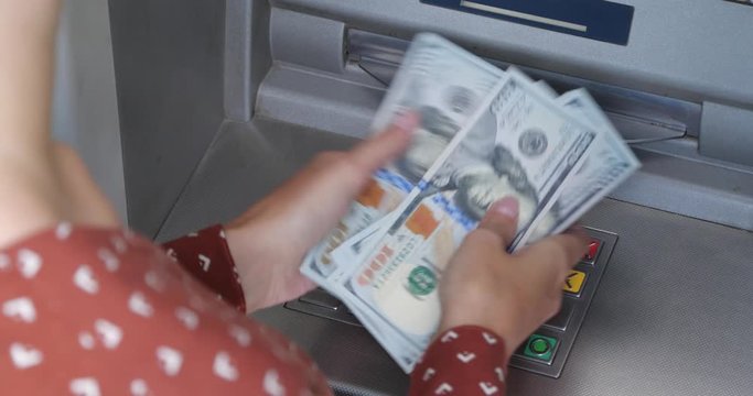 Woman counting money near cash machine outdoors, closeup