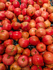 Delicious and good looking red pomegranate stacked in the store for sale. Healthy and refreshing and juicy fruit wallpaper background