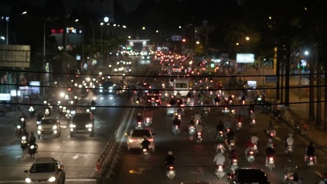 Blurred footage of transport in Ho Chi Minh. Travel in Ho Chi Minh city by a motorbike. Royalty high-quality free stock footage of slow moving traffic with lots of motorbike, bus, car in night city