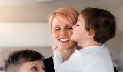 A young woman with two children indoors at home, having fun.