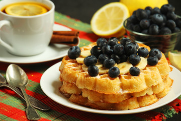 Belgian waffles with blueberry and a cup of tea with lemon