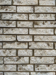 Old looking retro white horizontal stone rock bricks on an outdoors wall of a building