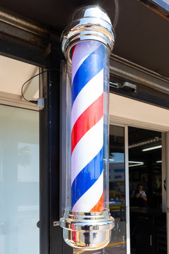 rotating barber pole with red white blue stripes hair salon shop sign