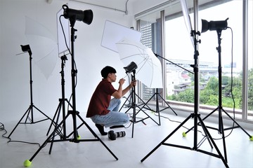 Photographer working with equipment lighting system camera portrait professional studio set up position
