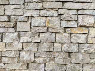 Stone rock brick tiles stacked and making an interesting natural looking facade wall for exterior of a building or house