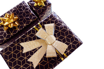 Three black gift boxes with a geometric pattern and a gold bow, isolate on a white background. Space for text..