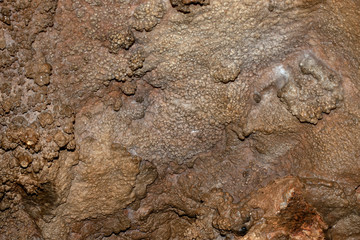 The cave wall sports multiple shapes and sizes of bumps and bubbles to form a unique background. Bokeh effect.