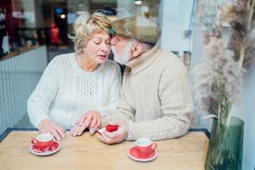 Senior man making marriage proposal to lady,dating sites for elder people.Propose happiness couple elderly caucasian relax weekend lifestyle in coffee shop. View froma above.Sun glare Retirement Plan.