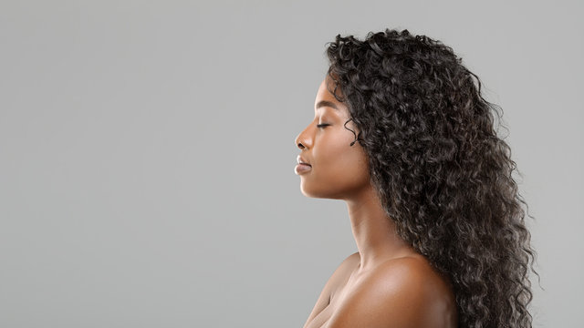 Profile portrait of beautiful african american woman with curly long hair