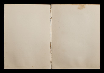 Antique book unfolded showing textured pages isolated on black background.